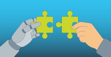 A robotic hand and a human hand are each holding a green puzzle piece that are meant to be put together.